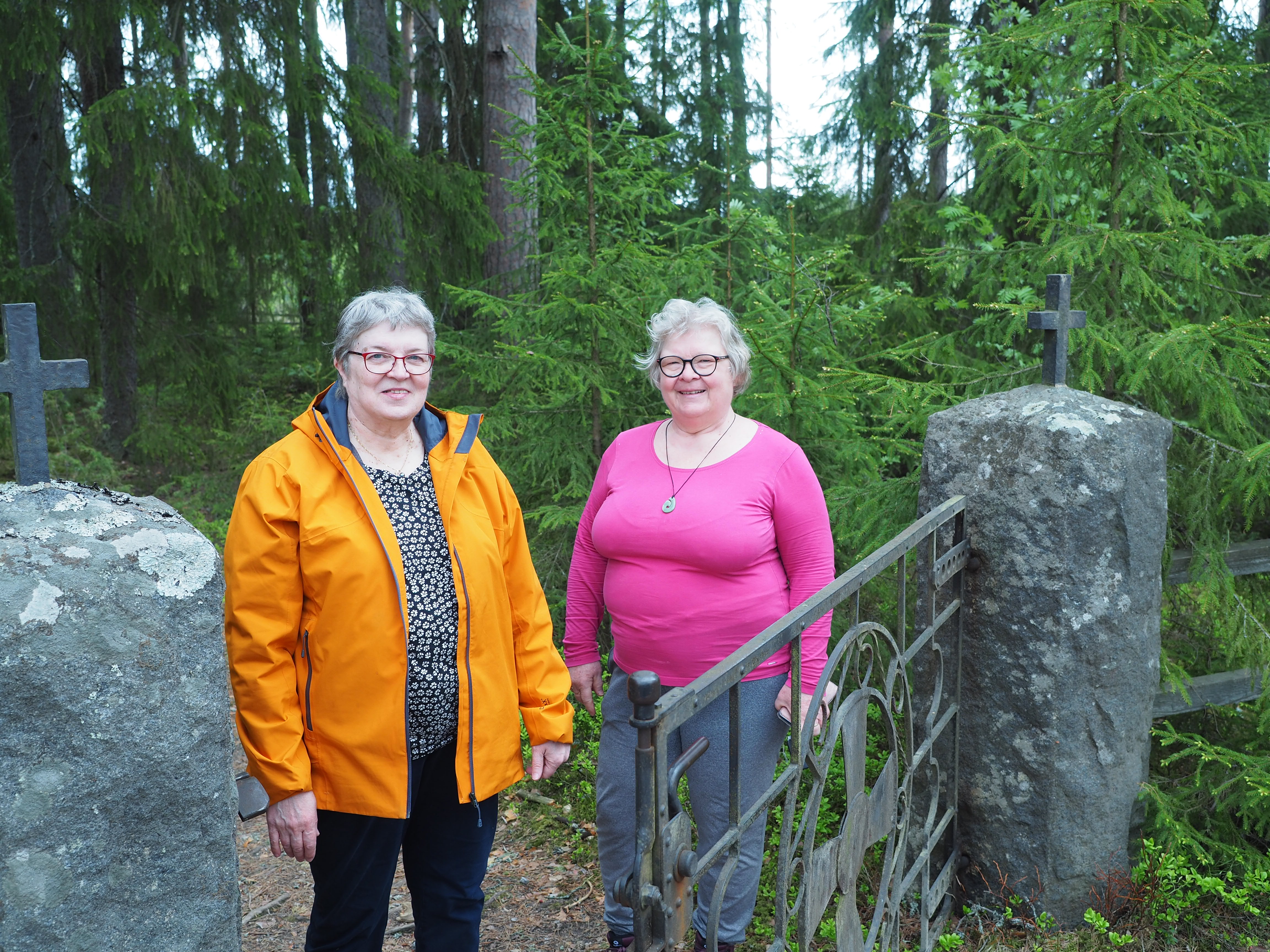 Eeva-Liisa Kovanen ja Eija Syrjälä Hartikan kirkkomaan portilla.